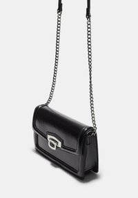 Czarna lakierowana torebka crossbody z zapięciem w srebrnym kolorze, prostokątny kształt i odczepiany łańcuszek na ramię. Gładka faktura z przeszywanymi detalami.