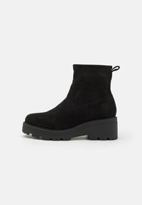 Svarte suede ankelstøvler med en kraftig plattform, rund tå, minimal søm, og en pull tab for enkel påkledning. Strukturerte såler for godt grep.