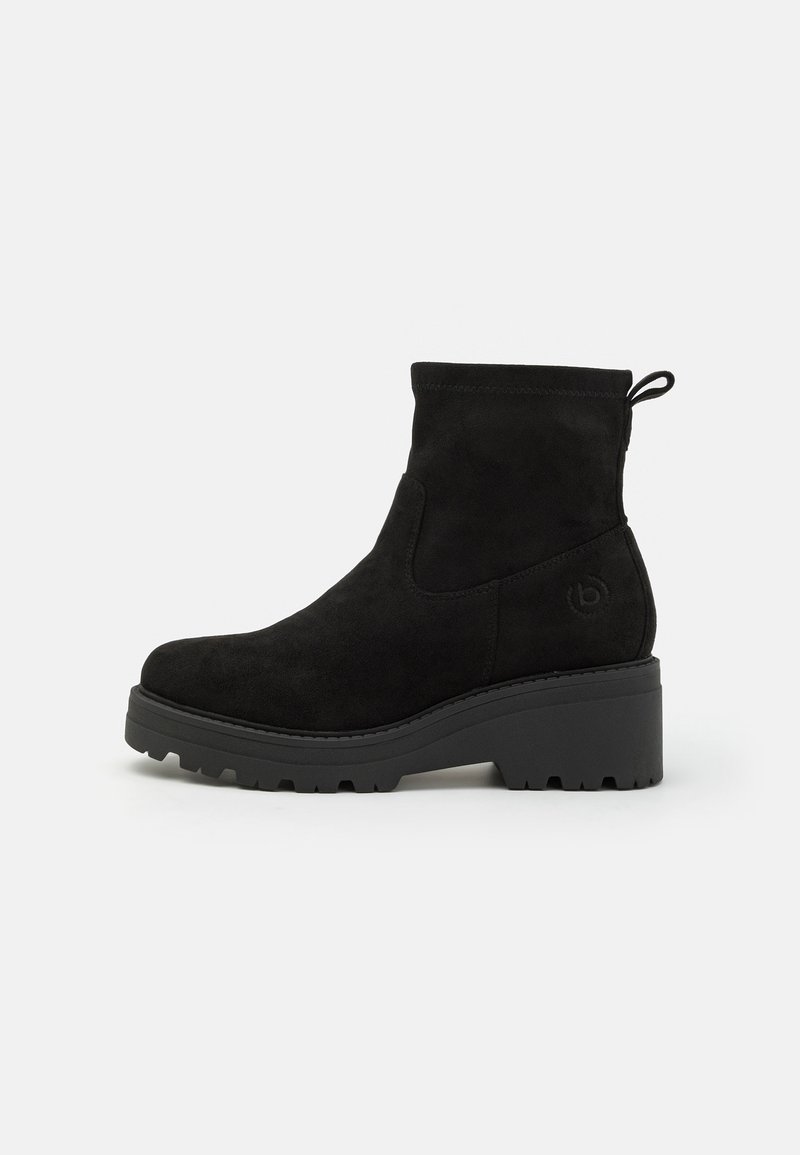 Svarte suede ankelstøvler med en kraftig plattform, rund tå, minimal søm, og en pull tab for enkel påkledning. Strukturerte såler for godt grep.