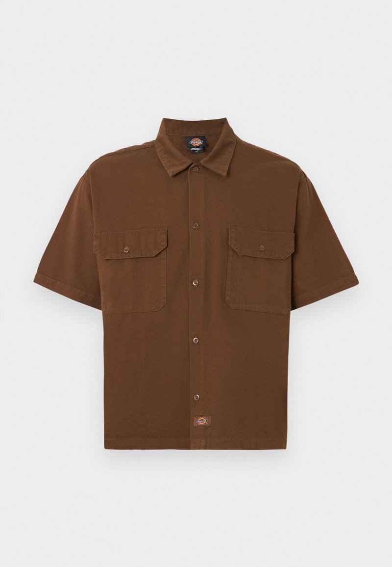 Camisa marrón de manga corta con botones, dos bolsillos delanteros con solapa y una pequeña etiqueta de logo de la marca cerca del centro inferior.