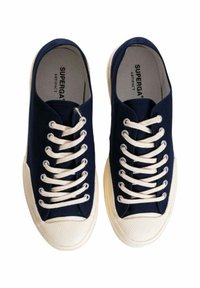 Sneakers in tela blu navy con punta tonda, suola in gomma color crema e sei occhielli per i lacci. Presentano lacci beige e accenti testurizzati.