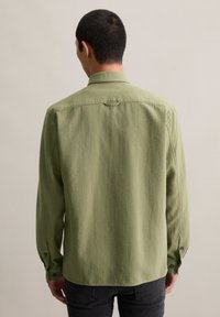 Green long-sleeve shirt with a textured fabric, button cuffs, and a back yoke detail. Designed for a casual fit.