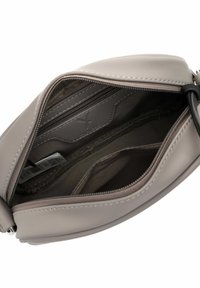 Wnętrze szarej skórzanej torebki z kieszenią na zamek, gładką fakturą, usztywnionym kształtem i kontrastującymi przeszyciami.