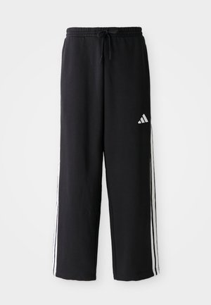 Black Adidas track pants with white three-stripe detailing on sides, elastic waistband with drawstring, and Adidas logo on right thigh.