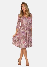 Kietopuku vaaleanpunaisella, violetilla ja ruskealla paisley-kuviolla; sisältää viisi-osa hihat ja sidottavan vyötärön. Sileä kangas ja polvipituus.