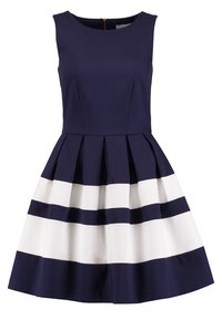 Robe sans manches bleu marine avec une jupe évasée, ornée de rayures blanches épaisses alternées, d'un design plissé et d'une fermeture éclair dans le dos.