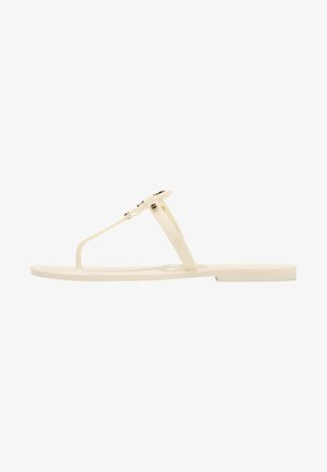 Flip-flop sandal in cream color, made of rubber. Designed with a thin strap and textured sole for grip. Simple, minimalist aesthetic.