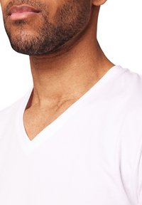 Weißes V-Ausschnitt-T-Shirt aus einem weichen, glatten Stoff, mit einem klaren Ausschnitt. Nahaufnahme hebt die Textur und Form um den Hals hervor.