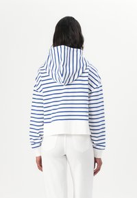 Haut crop rayé blanc et bleu, avec capuche, coupe décontractée, poignets côtelés et ourlet blanc uni.