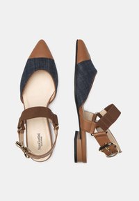 Zapatos planos con puntera afilada, acentos de cuero marrón, parte superior de tela de mezclilla y una cinta elástica marrón con detalle de hebilla.