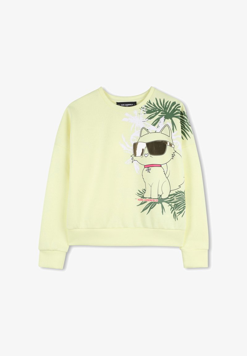 Sweat-shirt jaune représentant un chat cartoon portant des lunettes de soleil, entouré de feuilles de palmier vertes. Le tissu est doux avec une coupe décontractée et des poignets côtelés.