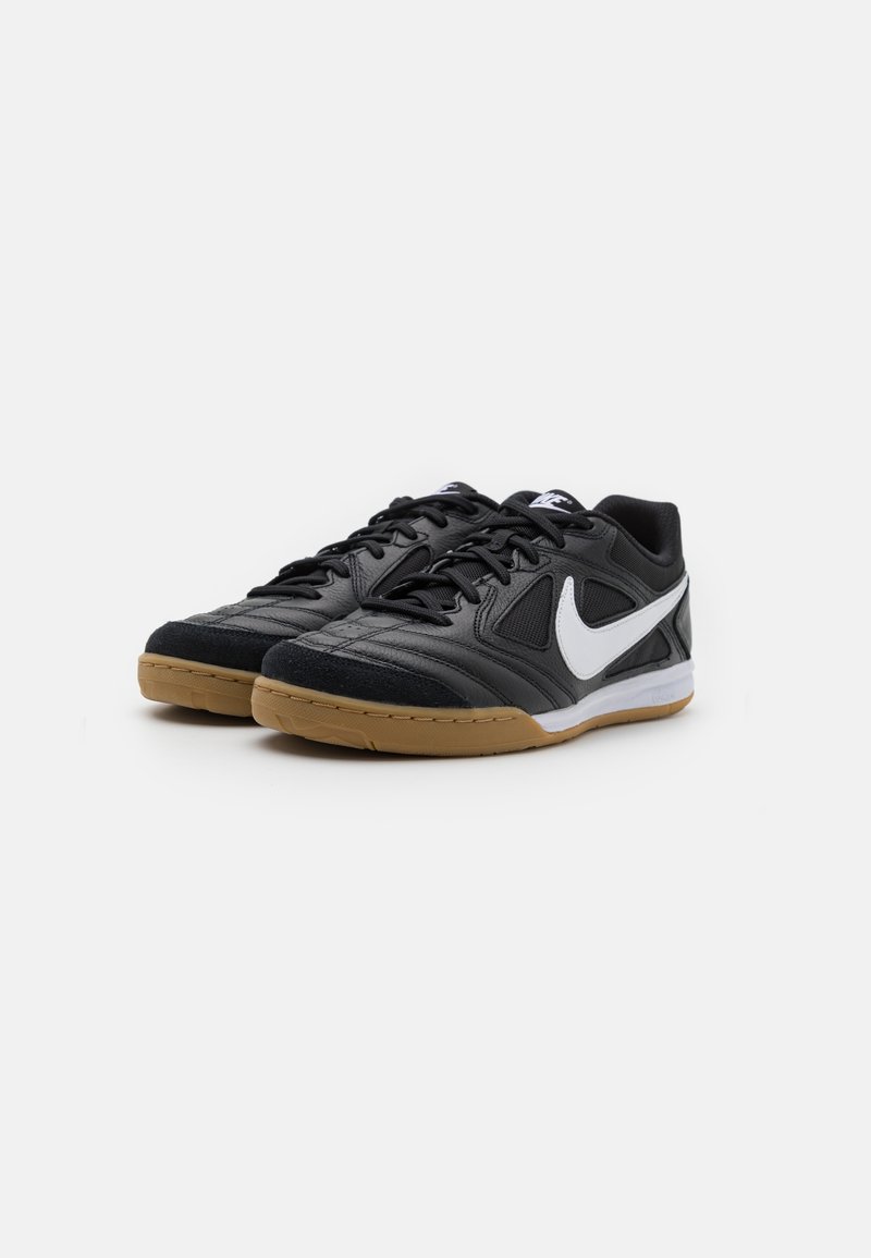 Baskets de sport noires avec une tige en cuir texturé, accent logo blanc et semelle en caoutchouc gomme ; conception à lacets avec col rembourré.
