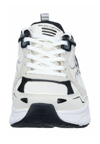 Witte en zwarte sneaker met een bovenwerk van mesh, textuuraccenten en een dikke witte zool. Voorzien van witte veters en een trektas aan de achterkant.