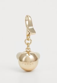 Portachiavi color oro con un ciondolo rotondo dalla superficie liscia, logo "FURLA" in rilievo e due piccoli accenti arrotondati nella parte superiore.