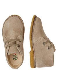 Beige mockaskor med rund tå, två snörhål och grå snörning. Mjuk textur och en gulaktig gummisula. Minimalistisk design.