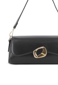 Bolso de hombro de cuero negro con un hebilla abstracta en tono dorado y correa ajustable, diseño minimalista, forma rectangular.