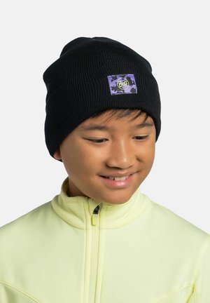 Black knitted beanie hat with a purple and black logo patch, featuring a snug fit and ribbed texture. Worn by a child in a light yellow jacket.