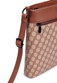 Křížová taška s nastavitelným hnědým koženým popruhem, texturovanou béžovou a hnědou tkaninou se vzorem v zigzagu a přední kapsou na zip s �černým táhlem.