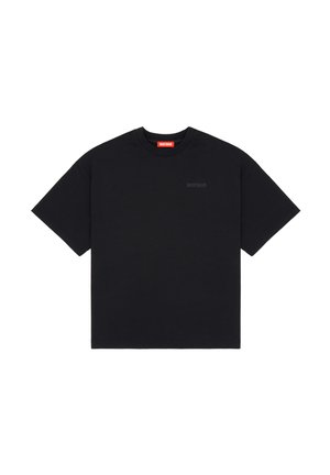 Μαύρο κοντομάνικο t-shirt με στρογγυλή λαιμόκοψη, με μικρό, διακριτικό κείμενο "WRSTBHVR" στο στήθος και κόκκινη ετικέτα στο εσωτερικό της λαιμόκοψης.
