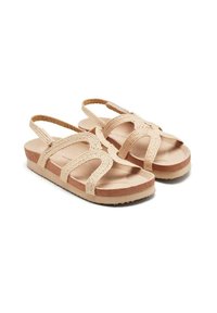 Sandalias beige con correas de tela trenzada, suela de goma plana y ligera amortiguación. Diseño abierto con dos correas traseras ajustables para un mejor ajuste.