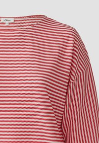 Rood en wit gestreept shirt van lichtgewicht stof. Heeft een ronde halslijn en korte mouwen met een gestructureerd oppervlak.