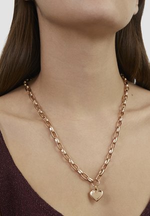 Goudkleurige ketting met ovale schakels, een hartvormig hangertje in het midden en een gepolijste afwerking voor extra glans.