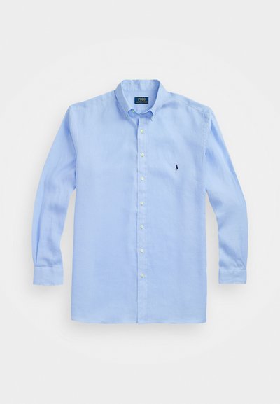 Gaiši zils garām piedurknēm krekls, kas izgatavots no kokvilnas, ar pogājamu apkakli un nelielu izšūtu logotipu kreisajā krūtī.