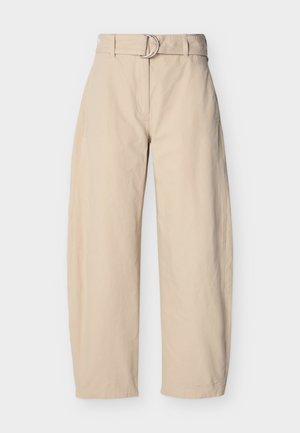 Pantalon beige à jambes larges en coton, doté d'une taille ceinturée avec une boucle ronde en métal, de poches latérales et d'une texture lisse.