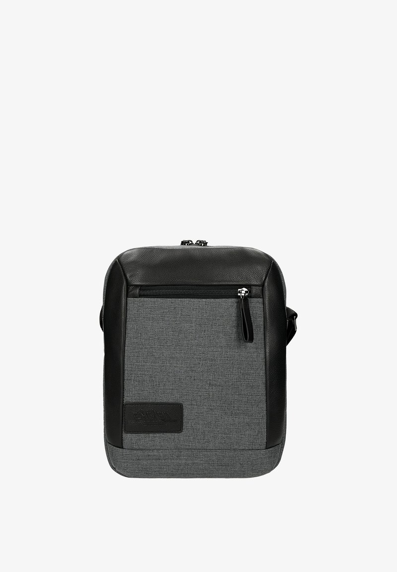 Borsa in tessuto grigio con dettagli in pelle nera, forma quadrata, tasca anteriore con zip e logo a patch. Include una tracolla regolabile.