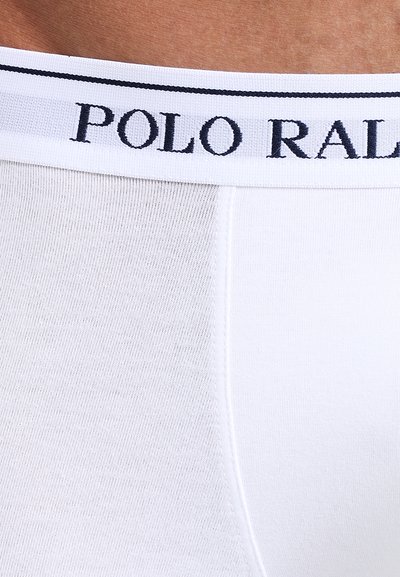 Boxers blancs en coton avec une ceinture noire "POLO RALPH LAUREN", texture lisse et design ajusté avec un léger éclat.