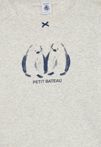 Light gray children's shirt with two simple navy blue penguin sketches and "PETIT BATEAU" text beneath them at the chest.