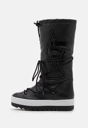 Botte noire mi-mollet avec semelle plateforme blanche, devant lacé, ornement de perles en zigzag et fermeture à cordon en haut.