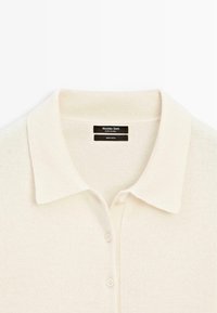 Vlněný polo svetr v krémové barvě s žebrovaným límcem, zapínáním na tři knoflíky a štítkem s nápisem "Massimo Dutti, 100 % vlna".