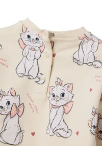 Tela de color crema con ilustraciones de gatos de dibujos animados con lazos rosas y corazones. Incluye cierres a presión y una textura suave.