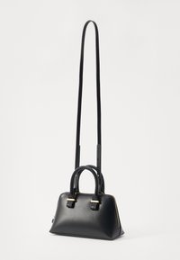 Sac à main en cuir noir avec doubles poignées, bandoulière réglable, quincaillerie dorée, design structuré et texture lisse.