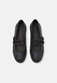 Czarne buty z okrągłym noskiem, dwoma regulowanymi paskami na górze, gumowymi podeszwami oraz teksturowaną wkładką wewnętrzną o geometrycznym wzorze.