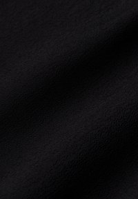 Schwarzer Textilstoff mit einer weichen, glatten Oberfläche, die subtile Variationen und Tiefe in der Farbe aufweist. Geeignet für verschiedene Anwendungen.