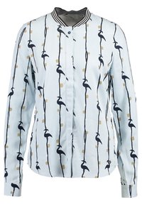 Ljusblå skjorta med vertikala mörkblå fågelsilhuetter och gyllene rutor på en silkig yta. Inkluderar en randig krage och knäppning.