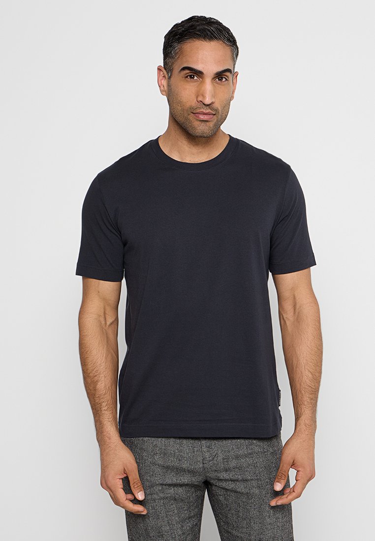 Granatowa koszulka z krótkim rękawem wykonana z miękkiej bawełny, z okrągłym dekoltem i prostym krojem, z subtelną etykietą z logo po boku.