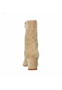 Beige Wildleder-Ankle Boots mit runder Zehenform, mittelhohem Blockabsatz, seitlichem Reißverschluss und glatter Textur. Schlichtes Design ohne sichtbare Muster.