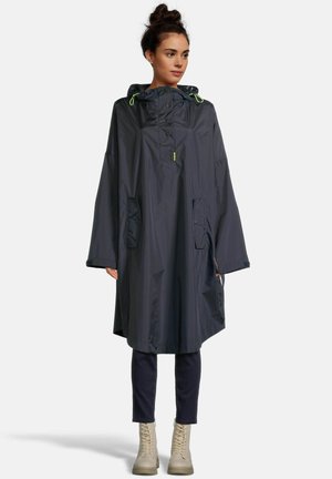 Waterdichte donkergrijze poncho met een capuchon, drukknoopsluitingen en twee zijzakken. Heeft felle groene accenten en een losse, rechte pasvorm.