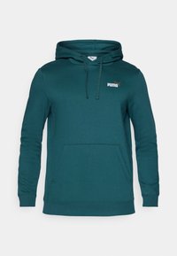 Felpa color teal realizzata in misto cotone, con tasca a marsupio e cappuccio con stringa. Piccolo logo bianco Puma nella parte superiore sinistra del petto.