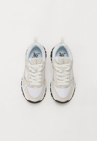 Sneaker sportive bianche e beige con tomaia in rete e camoscio, lacci bianchi, suola in gomma e linguetta sul tallone. Accenti di suola scura.