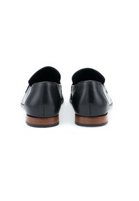 Zwarte leren schoenen met een gladde afwerking, platte hak en ronde neus, met een houten zool en subtiele stikdetails.