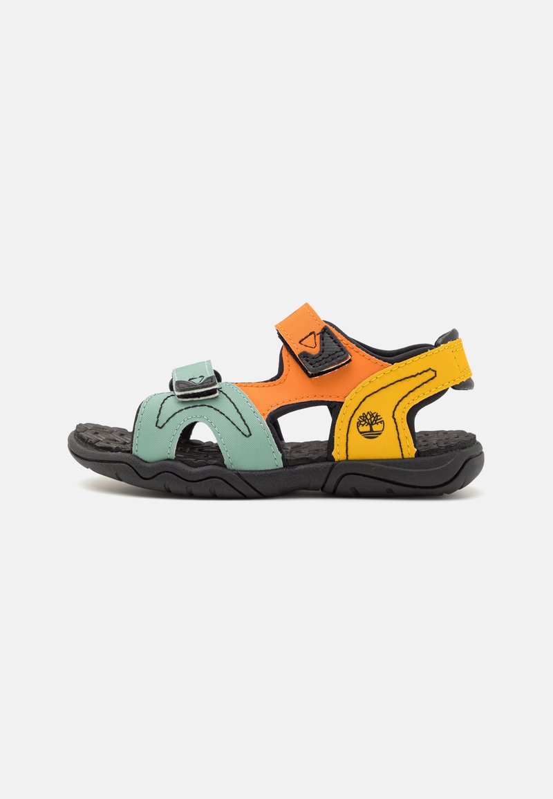 Sandale colorée en matériaux synthétiques vert menthe, orange et jaune avec découpes, sangles ajustables et semelle noire texturée.