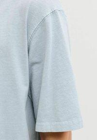 Hellblaues Baumwoll-T-Shirt mit Rundhalsausschnitt und kurzen Ärmeln, weich im Griff und schlicht im Design.