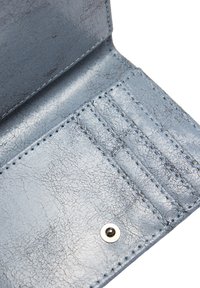 Jasnoniebieskie wnętrze portfela z ekoskóry z miejscami na karty, widocznym przeszyciem i metalowym zapięciem. Teksturowana powierzchnia.