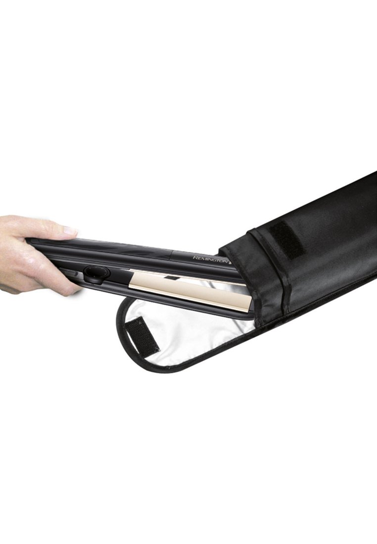 Mano colocando una plancha para el cabello Remington en negro y dorado dentro de una bolsa de almacenamiento resistente al calor de color negro, con cierre de Velcro.