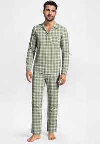 Groene en witte geruite pyjama set met lange mouwen en broek. Zachte stof, knoopsluiting aan de voorkant met zakdetails, rechte pijpen.
