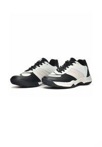 Scarpe da ginnastica nere e bianche con materiali in rete e sintetici, dotate di una suola testurizzata, lacci e un colletto imbottito per il comfort.